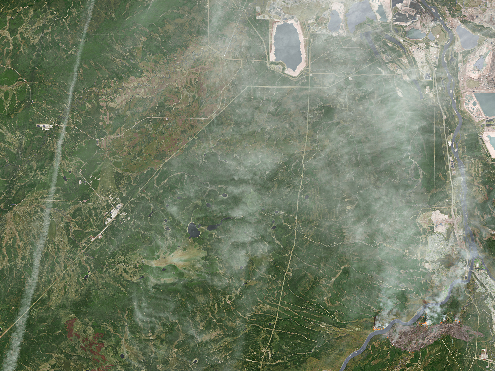 A destructive wildfire burned through Canada’s Northern Alberta region, razing neighborhoods in Fort McMurray and displacing tens of thousands of residents. (Source: NASA Earth Observatory) 